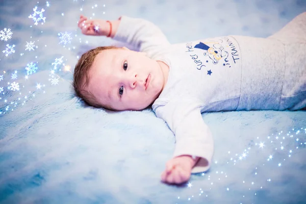 Happy baby boy on blue blanket