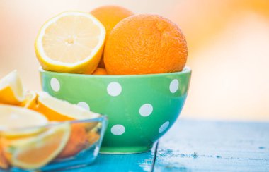 Mavi ahşap arka planda portakal ve limon dilimleri