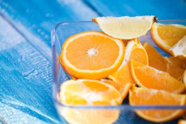 Mavi ahşap arka planda portakal ve limon dilimleri