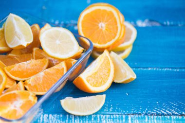 Mavi ahşap arka planda portakal ve limon dilimleri