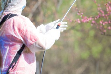 Coronavirus dezenfeksiyonu. Kamu parkında dezenfekte yapan tehlikeli madde işçisi