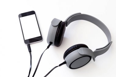 üzerinde izole mat gri müzik kulaklık bağlı smartphone ile