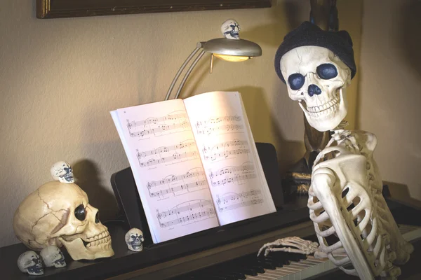 Familia de esqueleto de Halloween en un piano — Foto de Stock