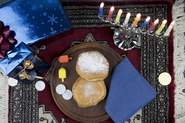 Hanukkah Menorah con velas encendidas, regalos, Dreidel y gelatina de relleno —  Fotos de Stock