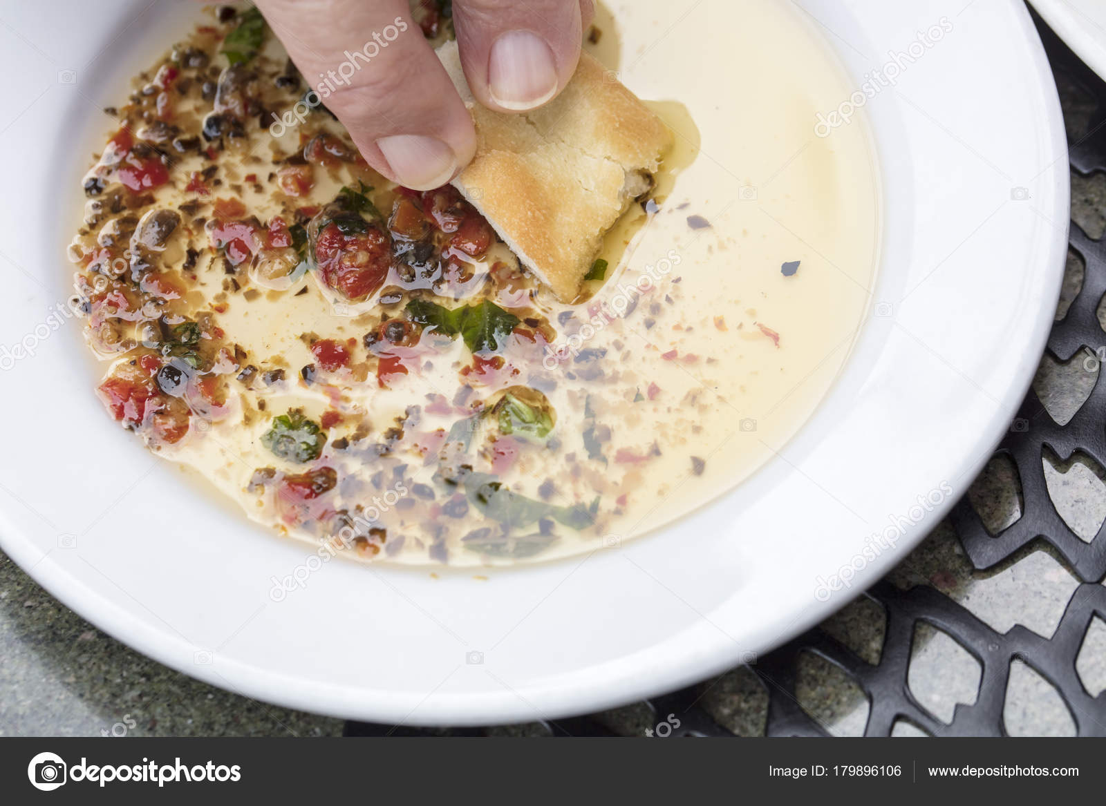 Man bread dipping in a seasoned olive oil on a white plate Stock Photo