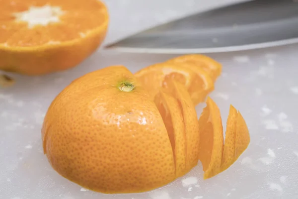 Mandarinka, plátky na prkénku s nožem a semínka — Stock fotografie
