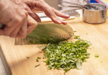 Şef fesleğen ve adaçayı doğradı.