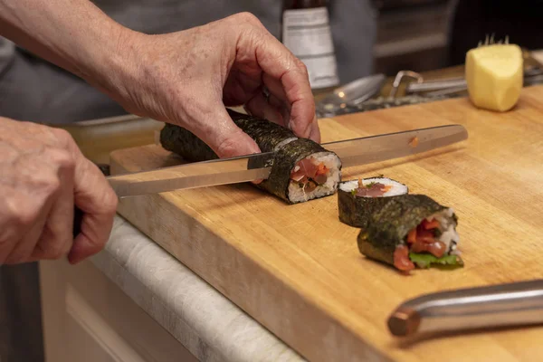 Sushi roll being sliced in a demonstaration class — Stock Photo, Image