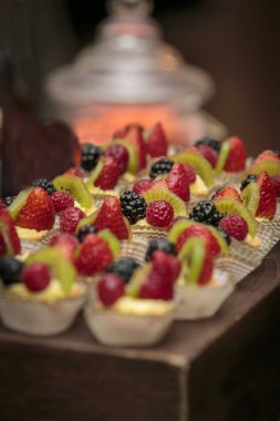 Çilekli, böğürtlenli ve kivili tartlı bir grup kutlama partisi için hazır bekliyor.