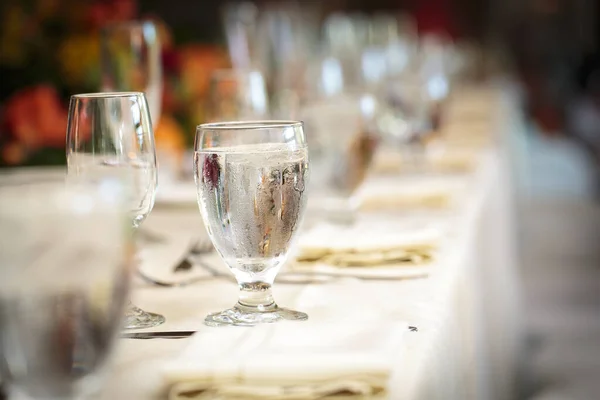 エレガントな装飾で氷の水で満たされた白いテーブルクロスと眼鏡とパーティーテーブルセット — ストック写真