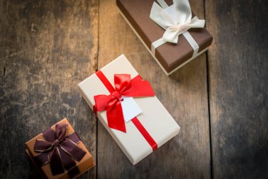 Üç kutu ahşap arka plan üzerinde hediye