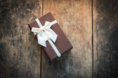 ahşap arka plan üzerinde kahverengi hediye kutusu
