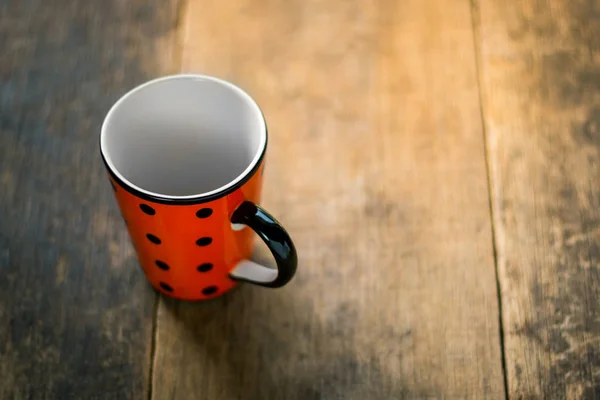 Gefleckte Tasse auf Holzgrund — Stockfoto