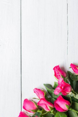 Beyaz ahşap arka planda pembe gül