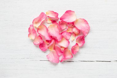 Beyaz ahşap zemin üzerinde şekil pembe yaprakları kalp
