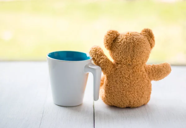 Relax concept. teddy bear with white coffee mug over bokeh green garden background. — Stock Photo, Image