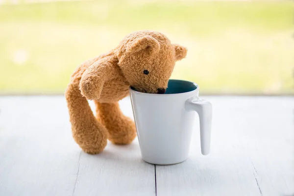 Relax concept. teddy bear with white coffee mug over bokeh green garden background. — Stock Photo, Image