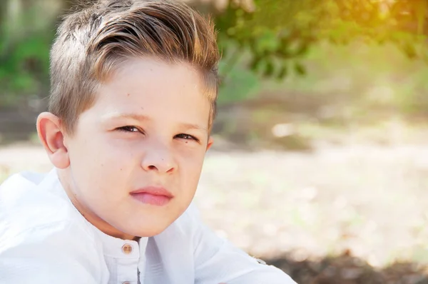 Portret van een close-up van de mooie jongen. Schattig schooljongen in het park — Stockfoto