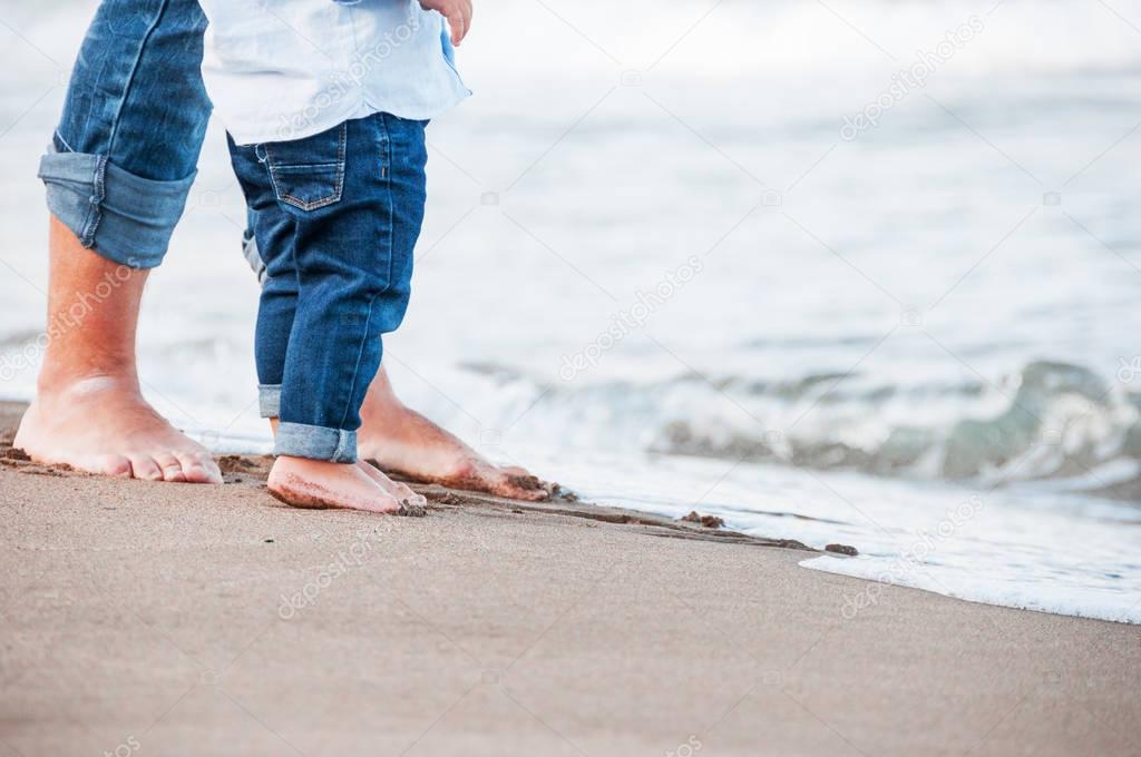 Bare feet of child and adult on the sea. vacation concept. Happy