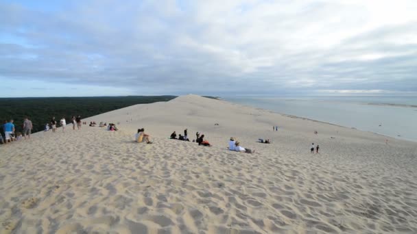 Personas y turistas en la duna de arena más alta — Vídeo de stock