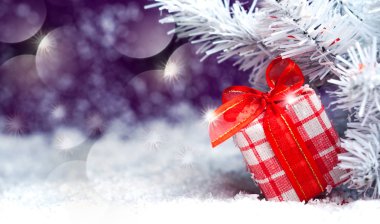 Noel hediyesi karda kırmızı yay ile