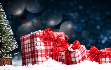 Karda kırmızı yay ile Noel hediyeleri