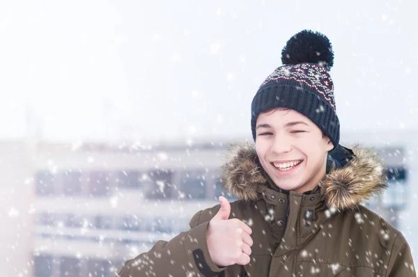 Young man on a city street during a snowfall — Stock Photo, Image