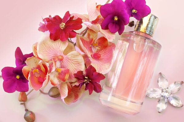 bottle of women's perfume on a pink background