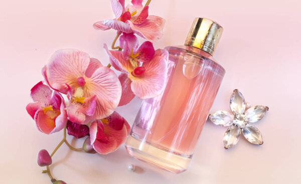 bottle of women's perfume on a pink background