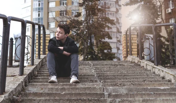 Trauriger junger Mann sitzt auf der Treppe — Stockfoto