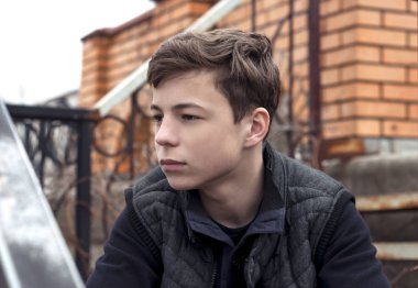 basamaklarında oturan üzgün genç adam