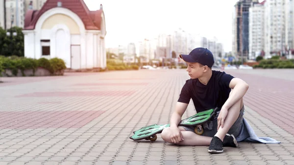 Jovem com um skate em uma rua da cidade — Fotografia de Stock