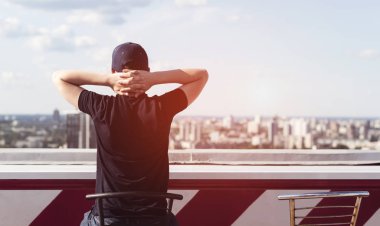 Yüksek bir binanın çatısında genç adam