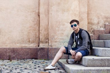 Şık genç merdiven basamaklarında oturan