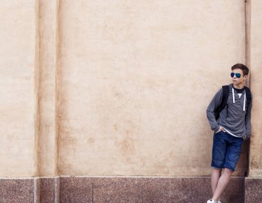 Şık genç adam duvara karşı ayakta