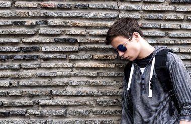 taş duvarın yanında ciddi genç adam