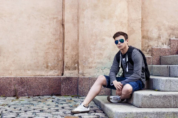 Şık genç merdiven basamaklarında oturan