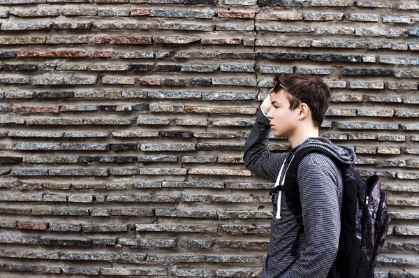 Joven serio cerca de la pared de piedras —  Fotos de Stock