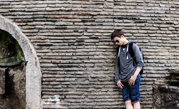 Poważny człowiek młody blisko ściany kamieni — Zdjęcie stockowe