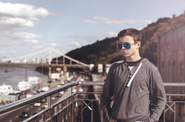 Young man on a bridge in a big city — Stock Photo, Image