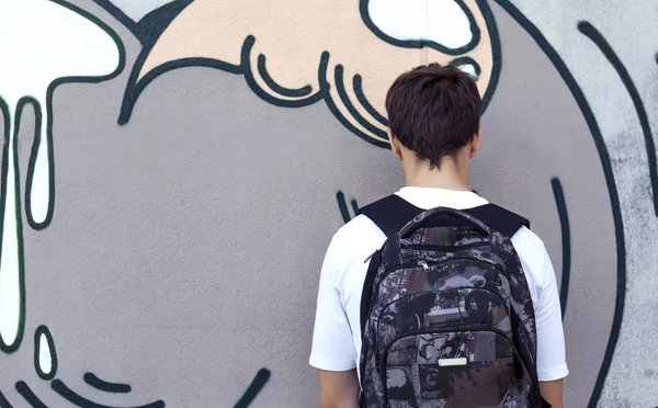 Adolescente con una mochila de pie cerca de una pared — Foto de Stock