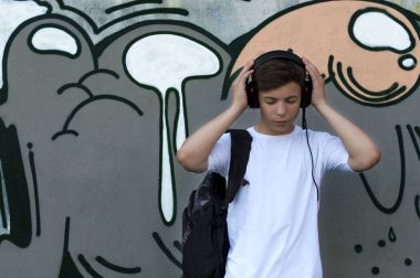 Kulaklıklı genç adam müzik dinliyor.