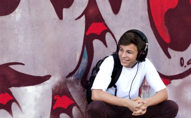 Kulaklıklı genç adam müzik dinliyor.