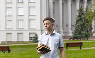 Gri building yakınındaki onun elinde bir kitapla genç adam