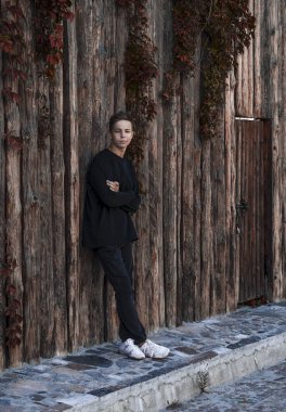 Yakışıklı genç adam ayakta yakınındaki bir ahşap duvar