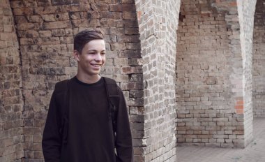 Yakışıklı genç adamın yanına bir tuğla duvar