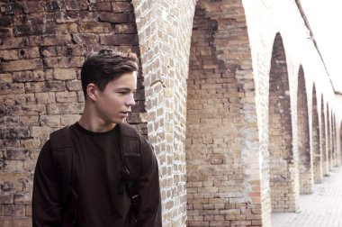 Yakışıklı genç adamın yanına bir tuğla duvar