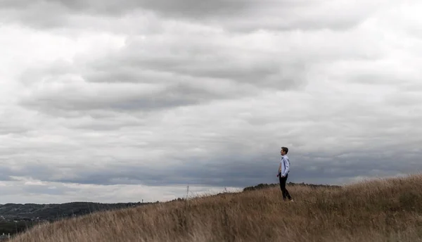 Hombre que se siente libre en un campo en una colina — Foto de Stock