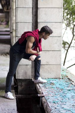  eski bir binada genç adam pencereden dışarı bakar