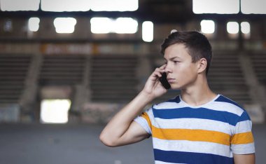 eski bir binada telefonda konuşan genç adam